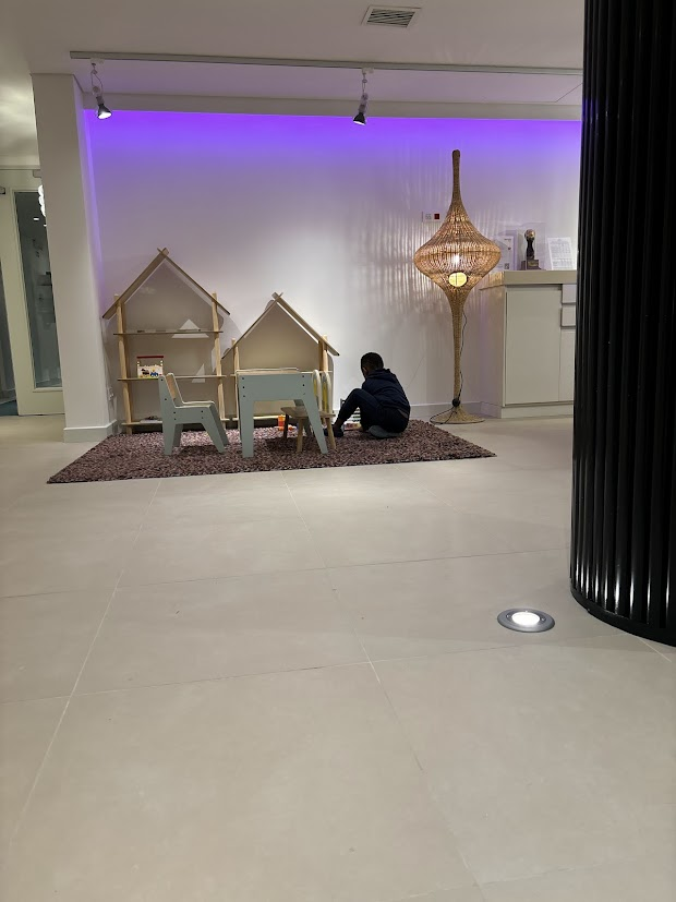 Play area for kids with table and chairs. Little boy playing.