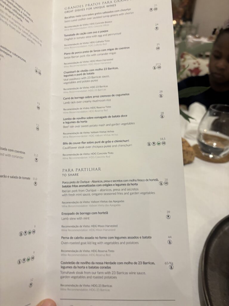 Portuguese restaurant menu showing meat and sharing dishes with wine pairings and prices in a fine dining setting