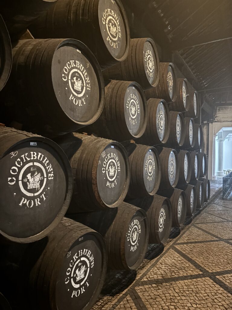 Port wine barrels stacked in rows at Cockburn's cellar in Porto, Portugal showing traditional aging process