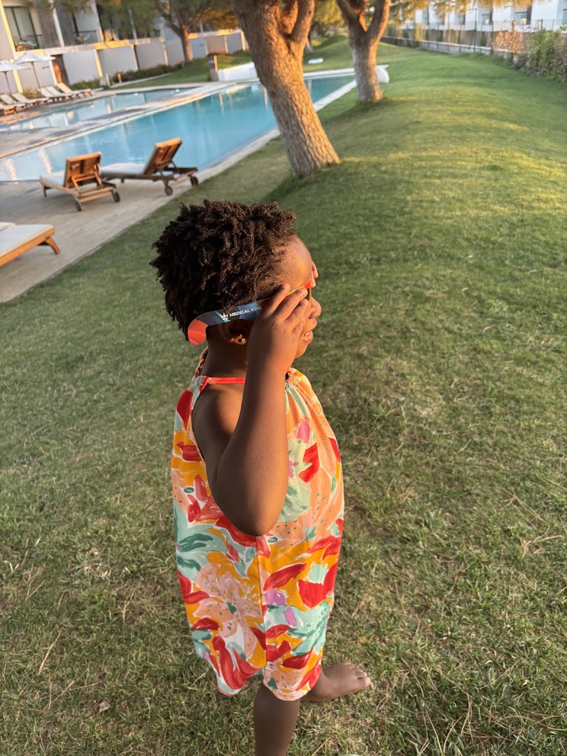 Child wearing eclipse glasses on the grounds at Octant Évora