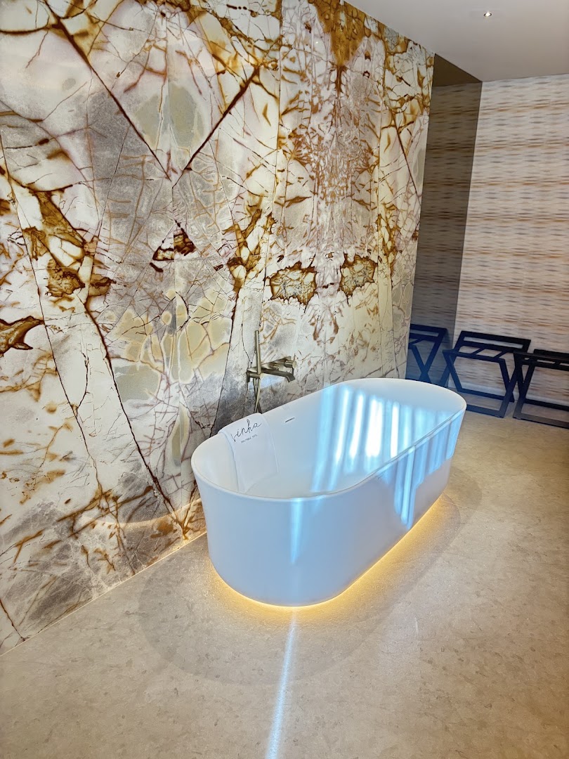 Freestanding bathtub beside patterned stone in my parents’ suite
