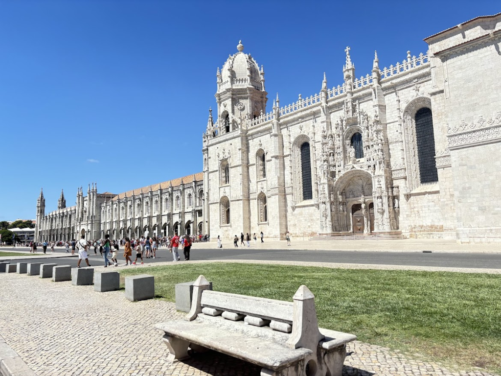 Jerónimos Monastery in Lisbon, Portugal - white stone Gothic architecture with ornate details under blue sky
