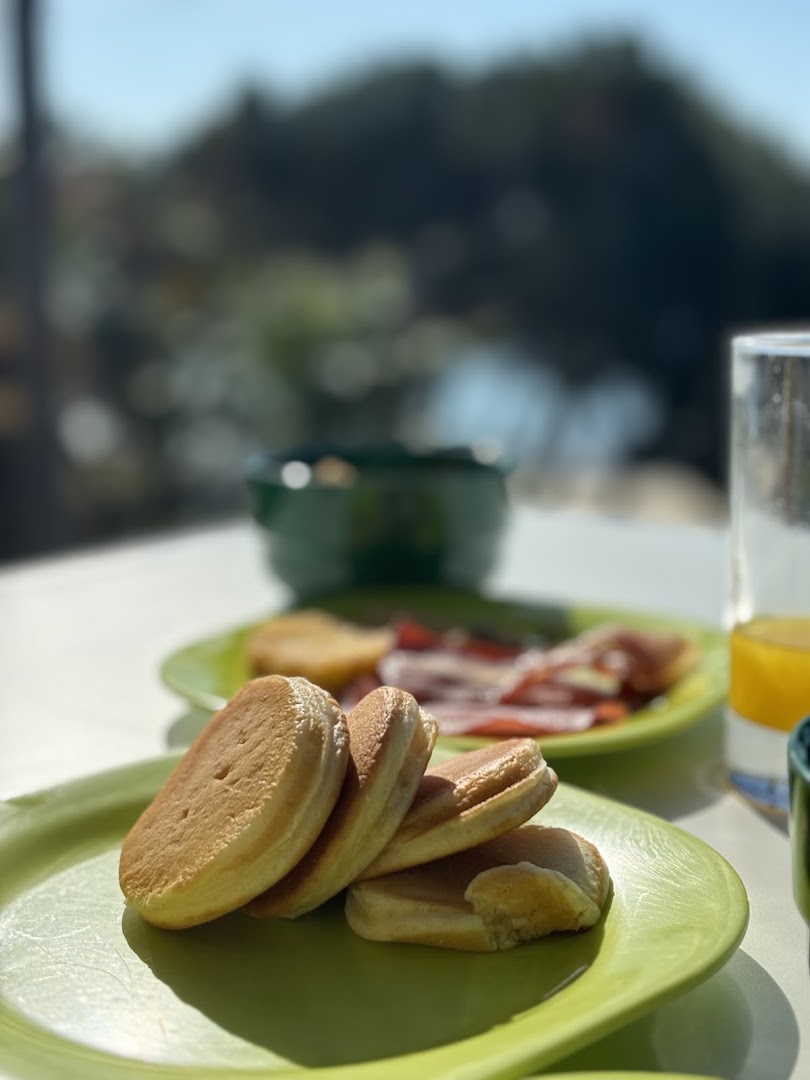Pancakes and breakfast plates beside a sunny window at Martinhal Sagres.