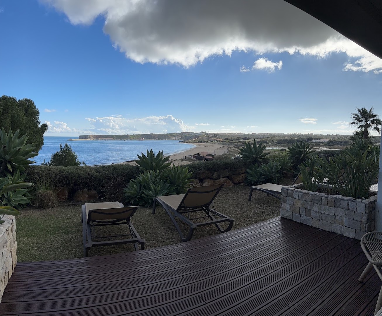 Wooden terrace with loungers and a beach view at Martinhal Sagres.