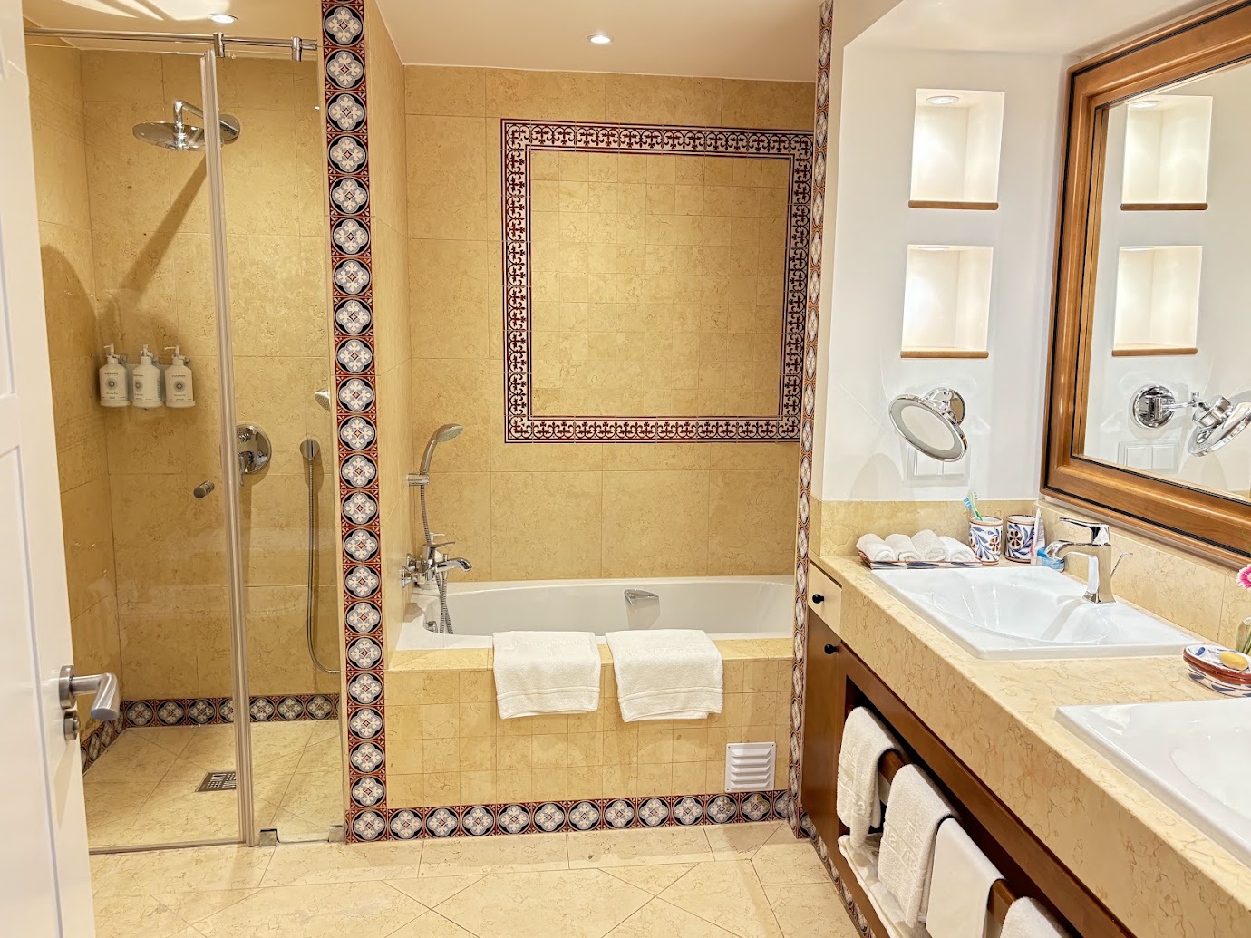 Bathroom with a glass shower, bathtub, and double vanity at Vila Vita Parc.