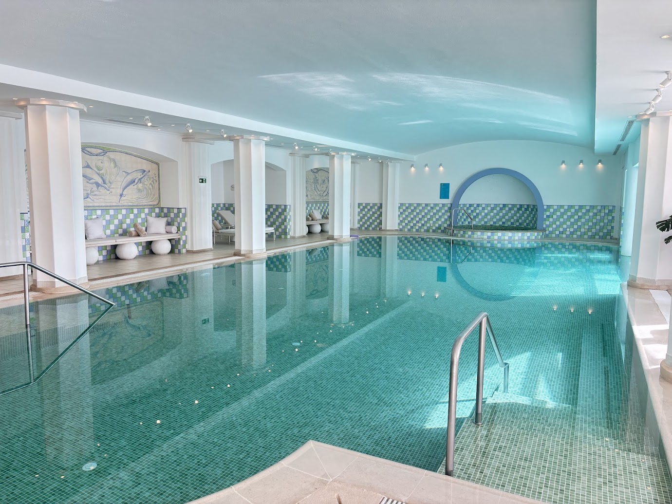Indoor swimming pool with turquoise water and white columns at Vila Vita Parc.
