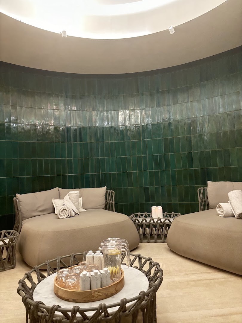 Round loungers, rolled towels, and green tiled walls in the spa relaxation area at Vila Vita Parc.
